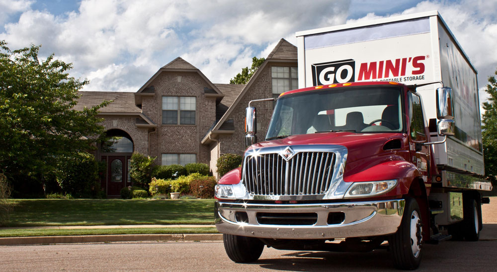 Go Mini's truck in front of large home